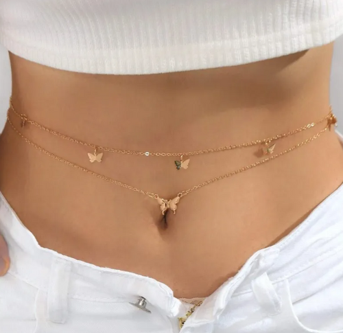 Gold butterfly necklaces on a person wearing a white top