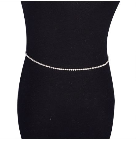 Silver waist chain on a black dress against a white background